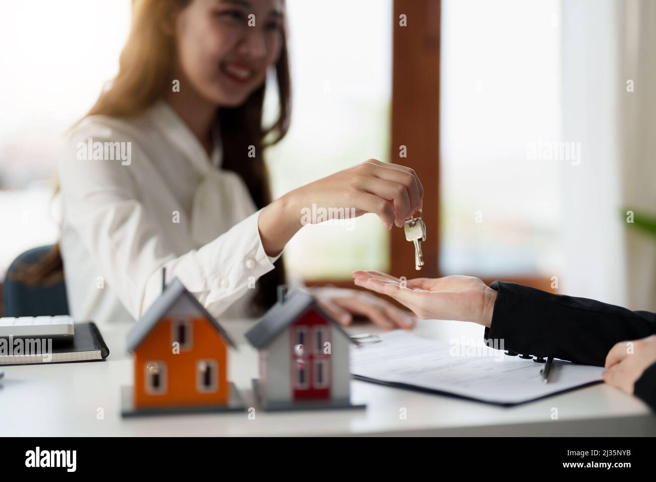 Agent immobilier tenant la clé de maison à son client après avoir signé l'accord de contrat dans le bureau, le concept de l'immobilier, le déménagement de la maison ou la location de la propriété Banque D'Images