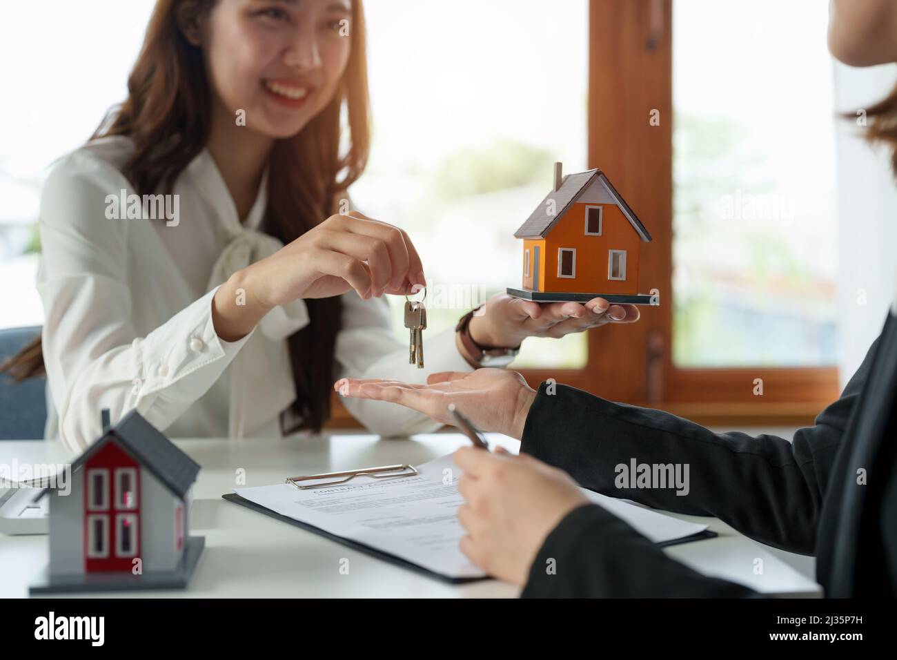Agent immobilier tenant la clé de maison à son client après avoir signé l'accord de contrat dans le bureau, le concept de l'immobilier, le déménagement de la maison ou la location de la propriété Banque D'Images