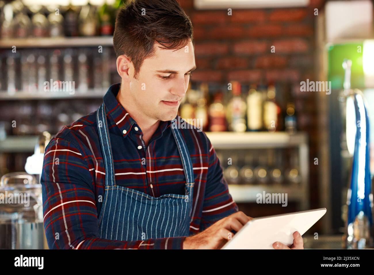 L'Internet peut vous aider à gérer une entreprise rentable. Photo rognée d'un propriétaire de restaurant à l'aide d'une tablette numérique. Banque D'Images