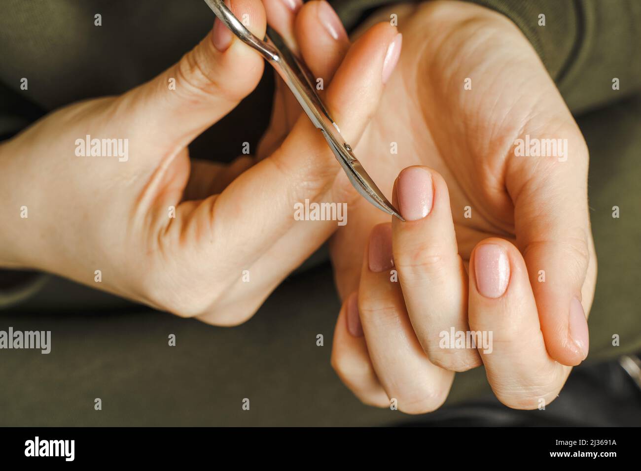 Les mains des femmes avec manucure tiennent un outil de traitement des ongles Banque D'Images