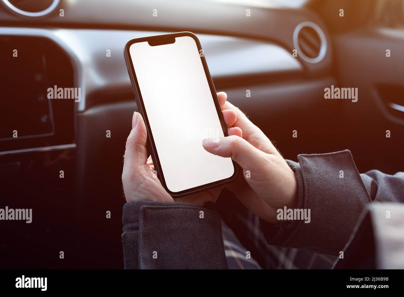 Femme passager dans la voiture utilisant un téléphone portable avec écran blanc vide comme maquette de copie, mise au point sélective Banque D'Images