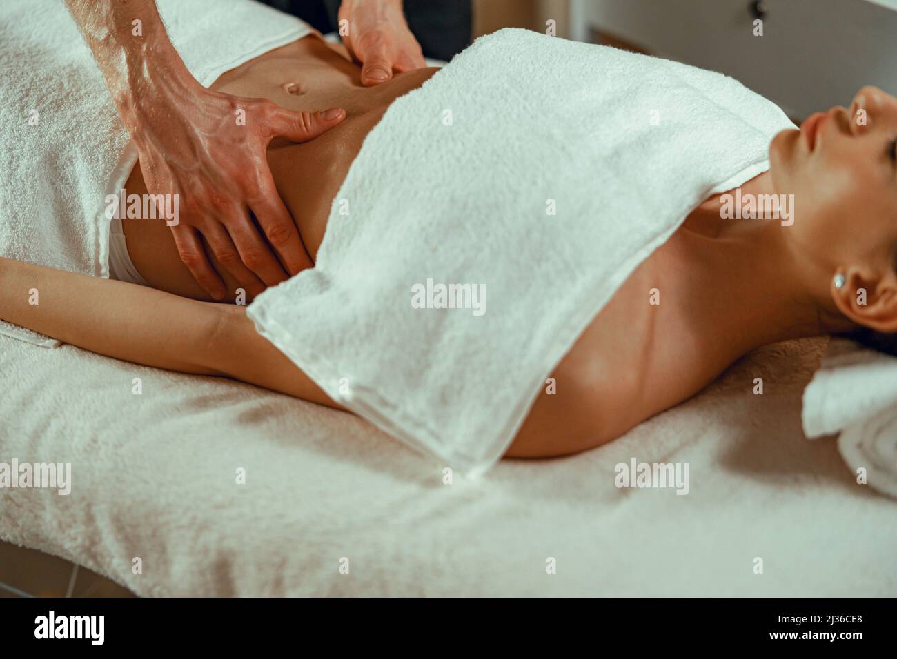 Une femme reçoit un massage relaxant, allongé sur un lit de repos au salon de spa Banque D'Images