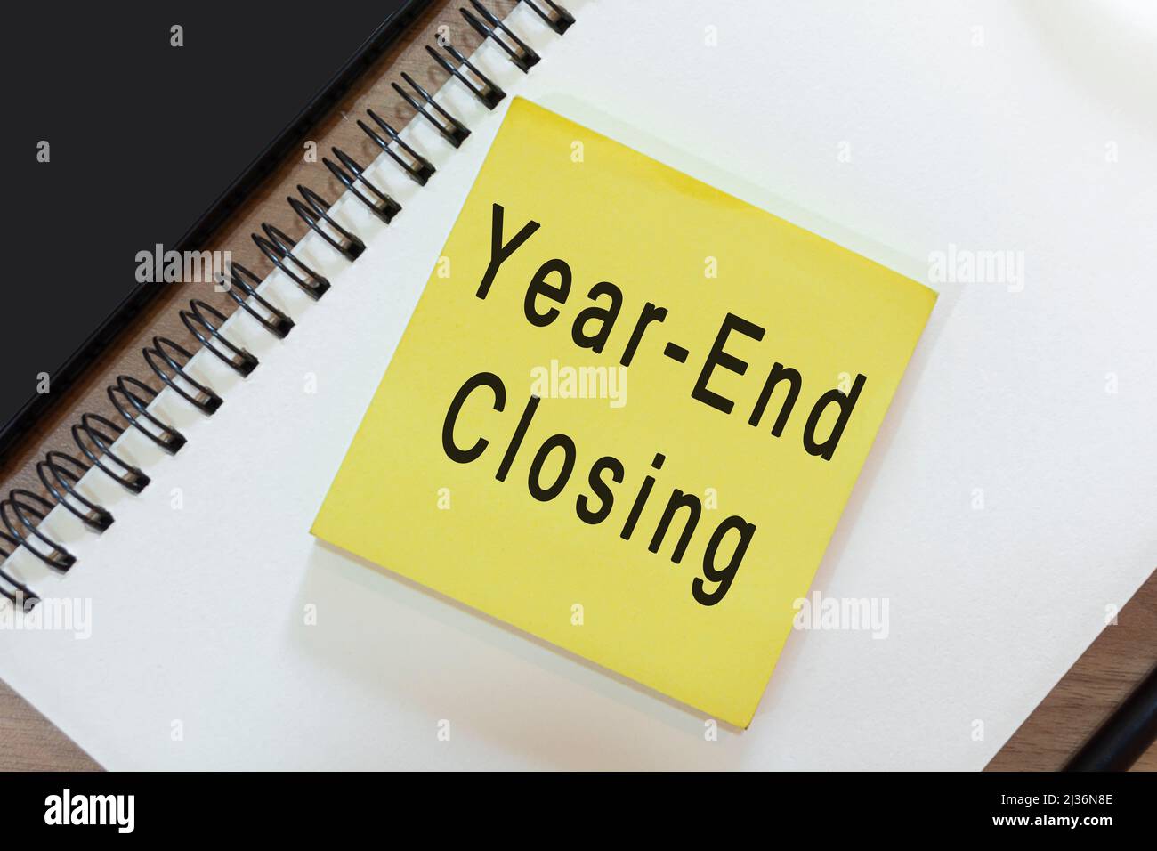 Texte sur note jaune avec bloc-notes sur bureau en bois - fermeture de fin d'année.Concept commercial et comptable Banque D'Images