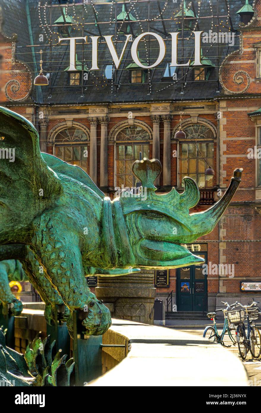 Statue de bronze représentant un dragon de chimère avec l'une des entrées du parc d'attractions Tivoli Gardens derrière lui. Copenhague, Danemark, Europe Banque D'Images