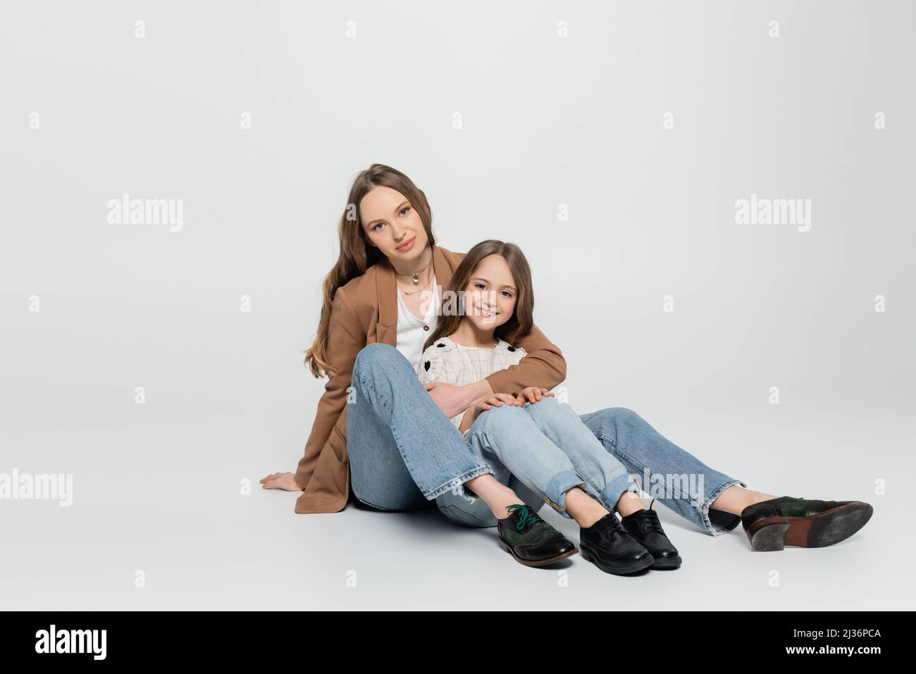 vue panoramique sur la mère et l'enfant dans des vêtements branchés, sur fond gris Banque D'Images