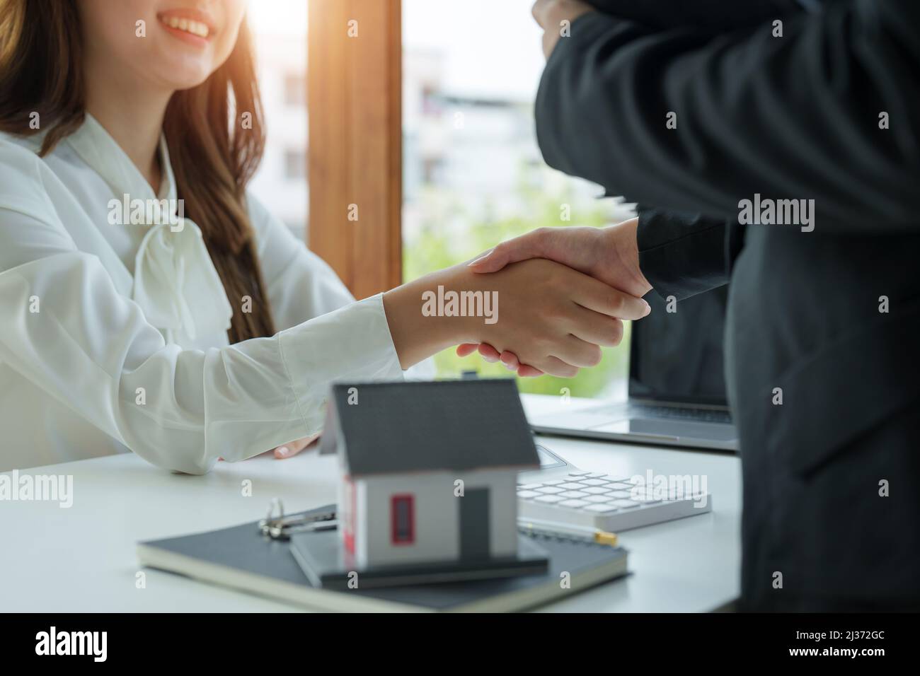 L'agent immobilier et le client se secouent les mains après avoir fini le contrat après environ assurance maison et prêt d'investissement Banque D'Images