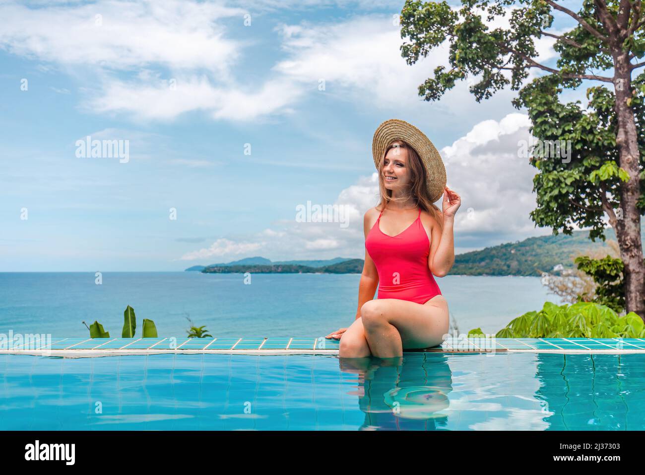 Femme en vacances tropicales se détendre dans la piscine dans un hôtel de luxe avec l'océan Banque D'Images