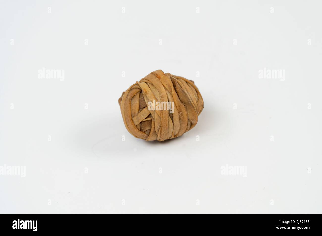 Utilisation d'un bracelet en caoutchouc marron pour la fabrication de balles rebondissantes en plastique, jouet pour enfant maison avec bande en caoutchouc, objet créatif isolé sur fond blanc Banque D'Images