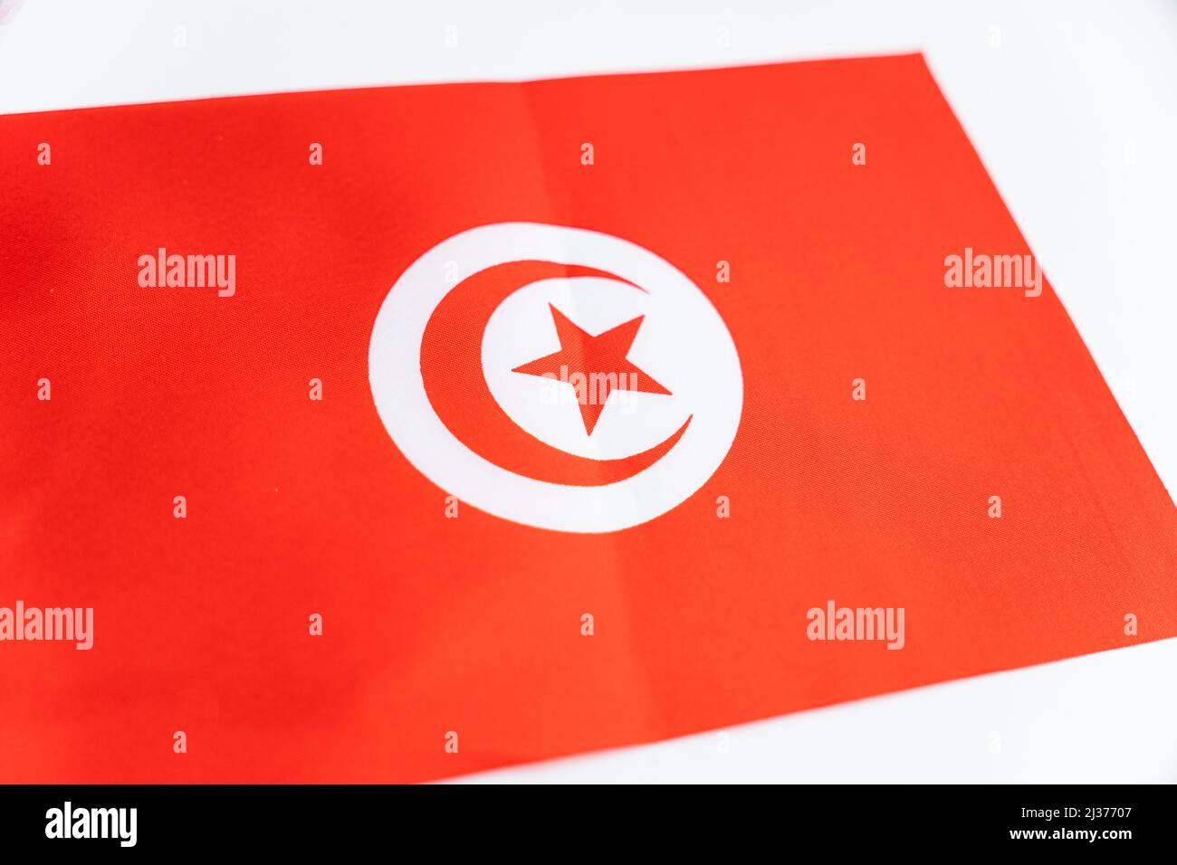 Tunisie drapeau tissu sur une table blanche. Gros plan sur le drapeau de la Tunisie. Drapeau tunisien. Banque D'Images