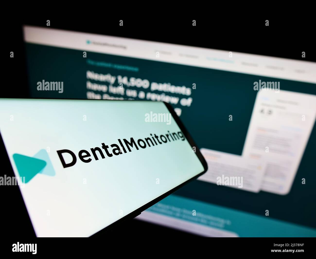 Smartphone avec logo de la société de santé française Dental Monitoring SAS sur écran en face du site Web d'affaires. Concentrez-vous sur le centre de l'écran du téléphone. Banque D'Images
