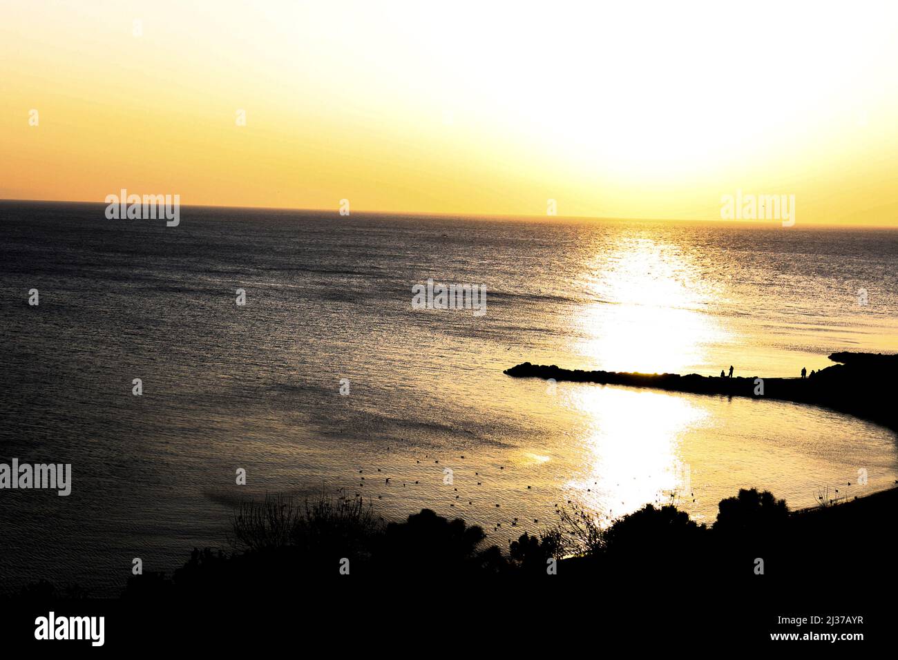 Coucher de soleil avec la mer sur la crique, les gens et les oiseaux sur la plage, vue de drone, ligne d'horizon, silhouette d'arbres et de paysage, photo à contraste élevé Banque D'Images