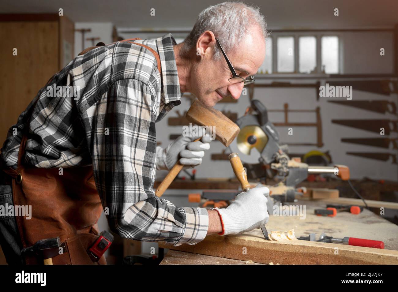 Sculpter du bois de menuisier avec marteau et burin. Photographie de haute qualité. Banque D'Images
