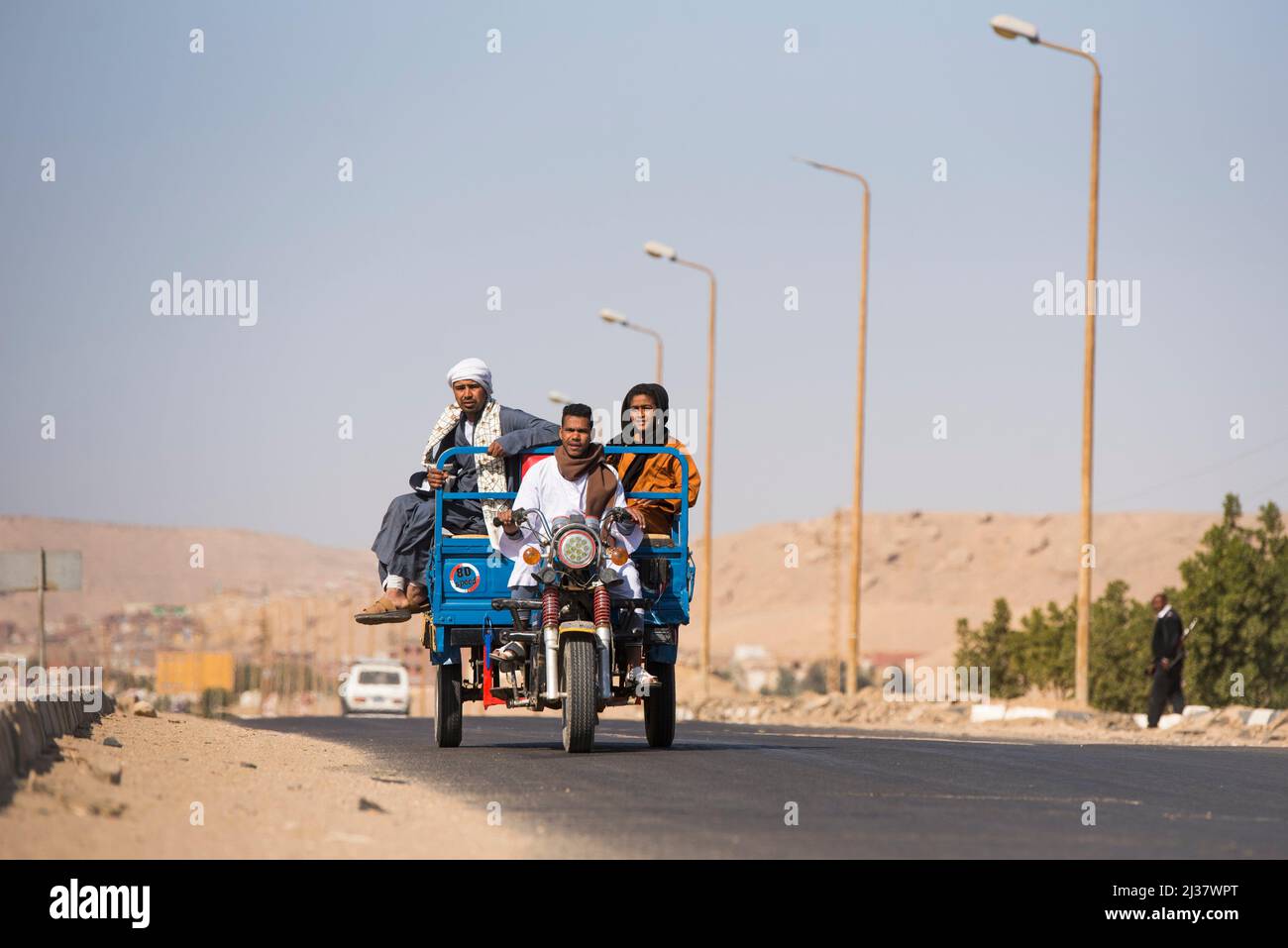 Famille voyageant sur un tricycle motorisé à un village sur le Nil près de la nécropole d'El-Kab, sur la rive est du Nil, en Égypte. Banque D'Images
