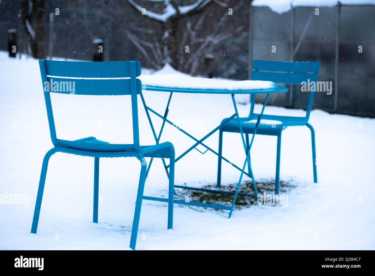 table et chaises bleues à l'extérieur dans un jardin enneigé Banque D'Images