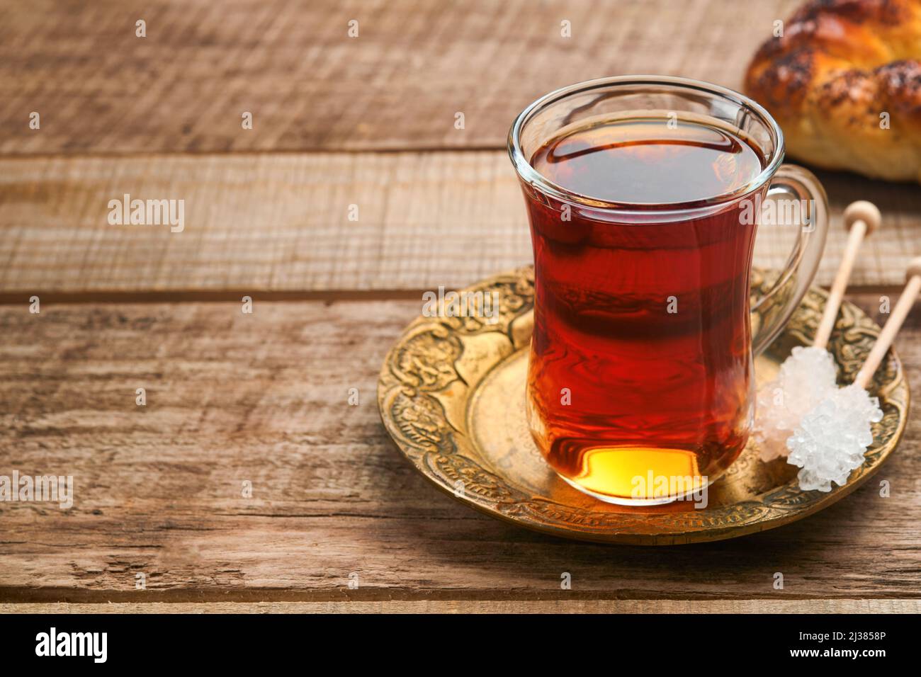 Thé noir turc. Tasse en verre de thé noir turc et bagel traditionnel turc croustillant sur fond de vieux rousstick. Concept de pâtisserie pour le petit déjeuner. Traditiona Banque D'Images