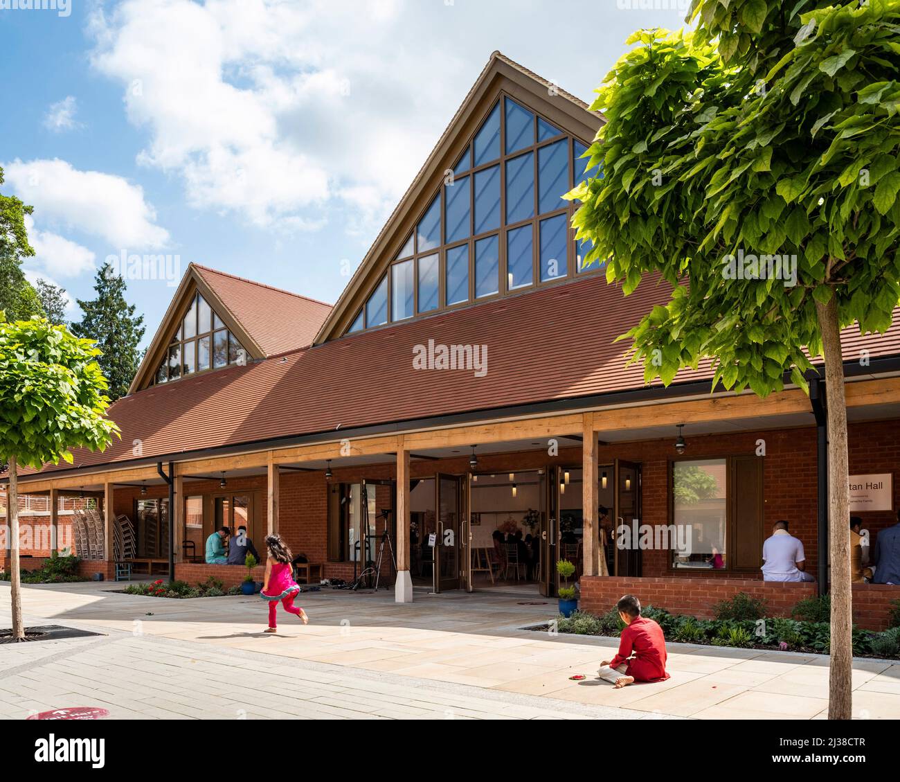 La cour cloître les enfants qui jouent. Bhaktivedanta Manor Haveli, Watford, Royaume-Uni. Architecte: Cottrell + Vermeulen Architecture Ltd, 2021. Banque D'Images