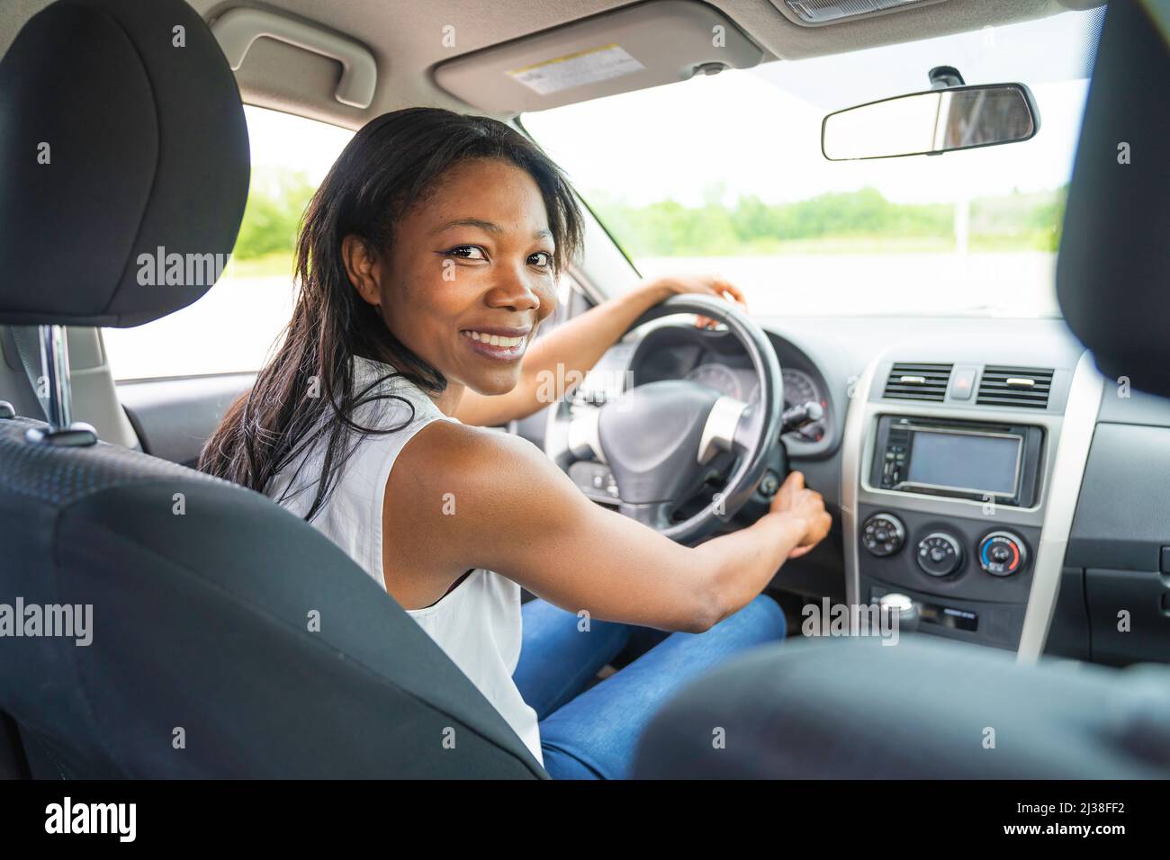 femme noire pilote assis dans sa nouvelle voiture Banque D'Images