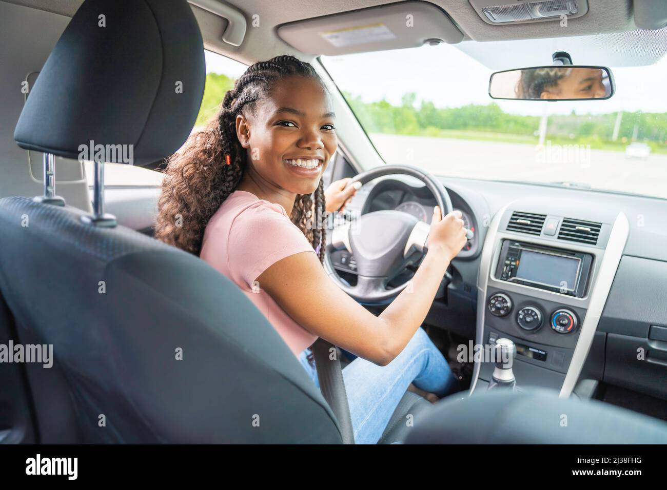 Jeune chauffeur adolescent noir assis dans sa nouvelle voiture Banque D'Images