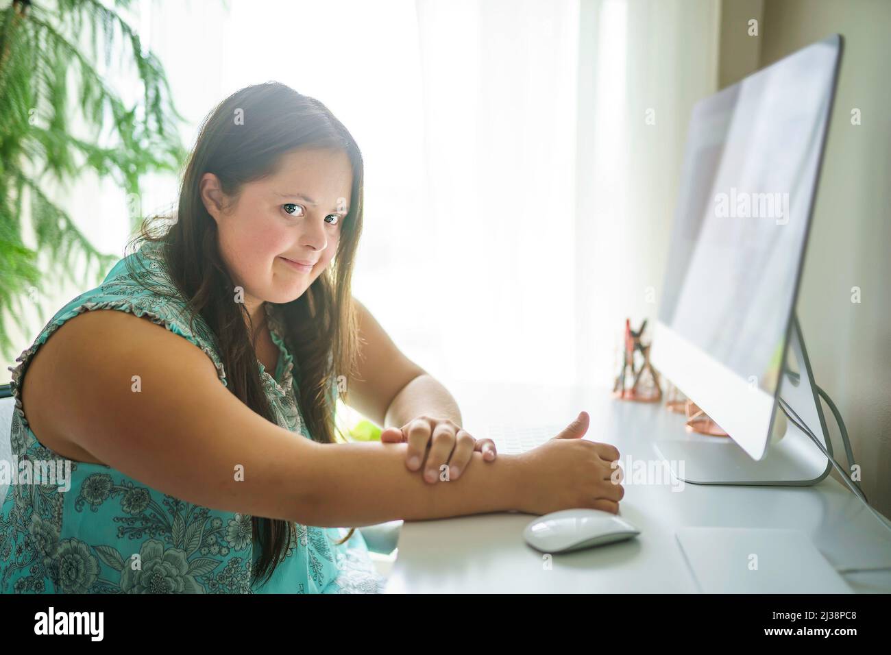 Portrait de trisomie 21 adulte travaillant sur ordinateur Banque D'Images