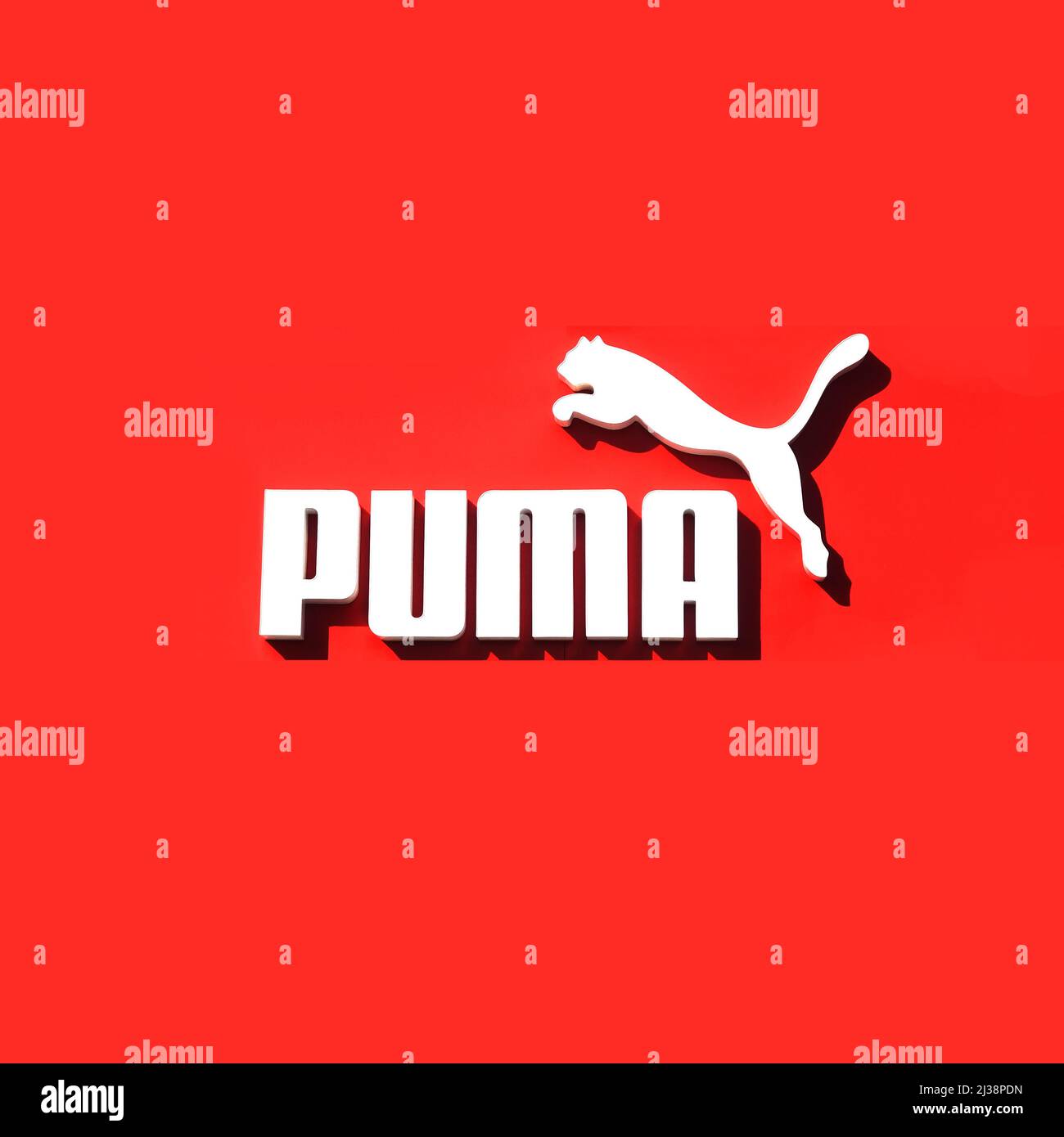 Lac Elsinire, CA, États-Unis - 4 avril 2022 : logo PUMA blanc sur le mur rouge de la boutique de vêtements de sport. Banque D'Images