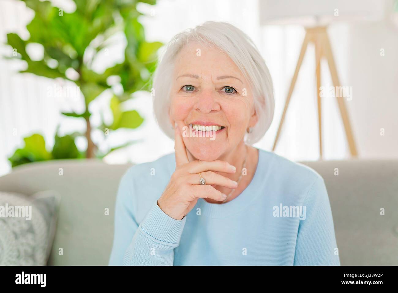 portrait de femme âgée assis sur le canapé à la maison Banque D'Images