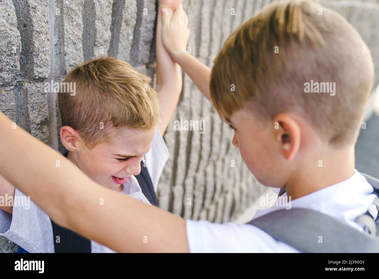 Les adolescents plus jeunes garçon cruel de perforation, d'intimidation physique, l'intimidation à l'école Banque D'Images