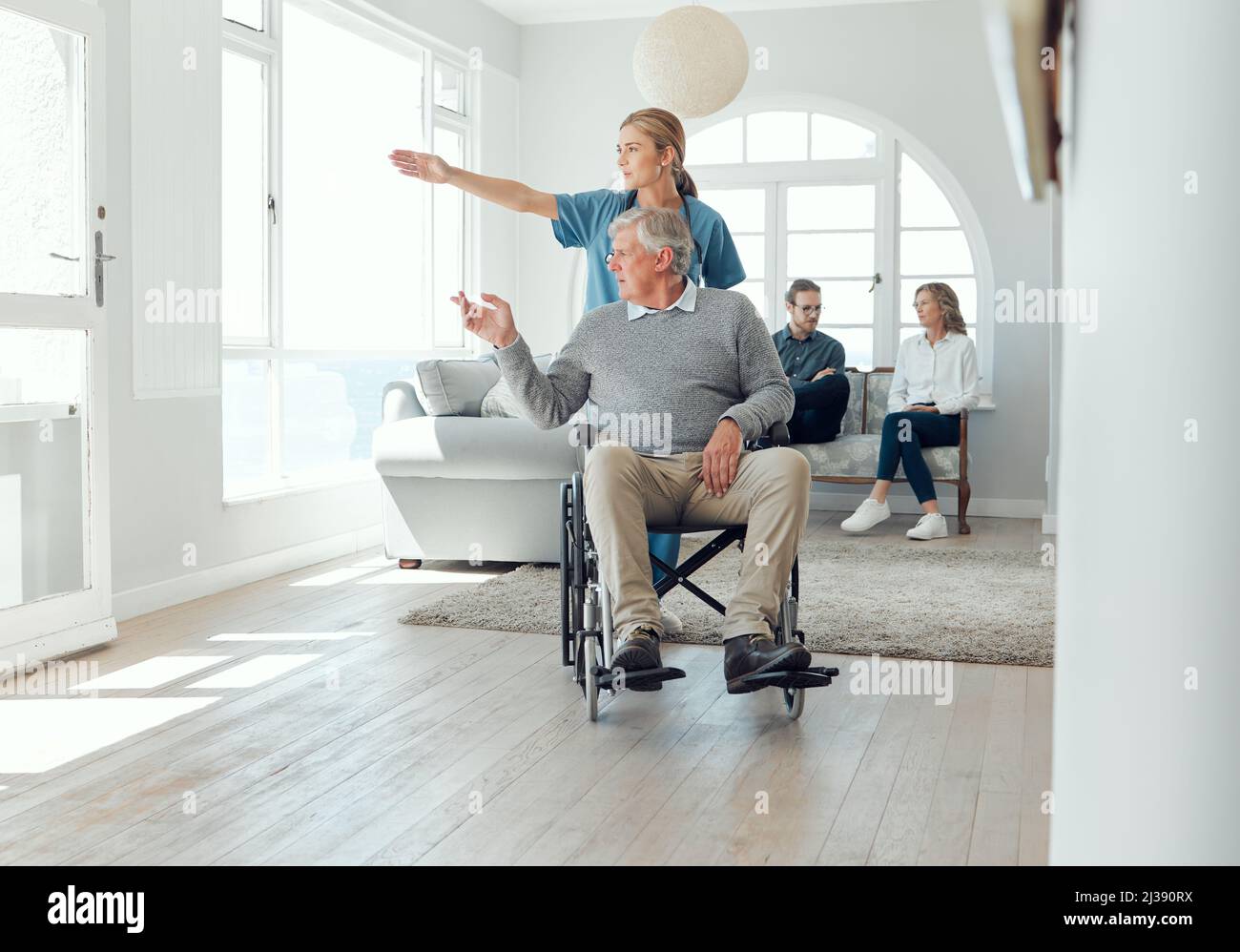 Levez les bras pendant que nous regardons à l'extérieur. Photo d'une jeune infirmière qui s'occupe d'un homme plus âgé en fauteuil roulant. Banque D'Images