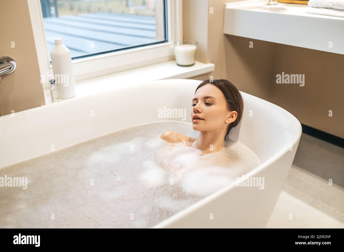 Jolie dame prenant un bain relaxant à la maison Banque D'Images