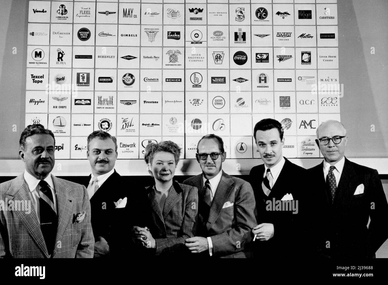 Plus important en affaires, six partenaires de Raymond Loewy Associates posent contre la fresque des marques de commerce d'American. Produit canadien britannique qu'ils ont conçu. Il s'agit de Raymond Loewy, William T. Snaith, Jean Thomson Loewy Bienfait, A. Barnhart, Carl L. Otto et John B. Breen. 11 avril 1949. Banque D'Images