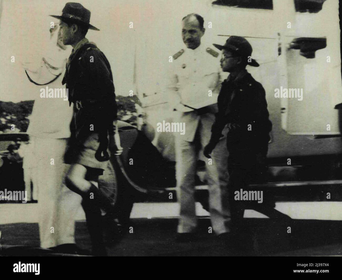 Le Roi garçon de Siam comme scout garçon -- le Roi garçon de Siam qui est revenu dans son propre pays après sa scolarité photographié comme il est arrivé au stade national en uniforme de scouts garçon vêtu. Il est suivi de son frère cadet, le prince Bhul Bhal. Au stade, ils ont assisté à une partie de la manifestation athlétique de cinq jours donnée par des garçons et des filles du pays. 11 décembre 1938. (Photo de Keystone). Banque D'Images