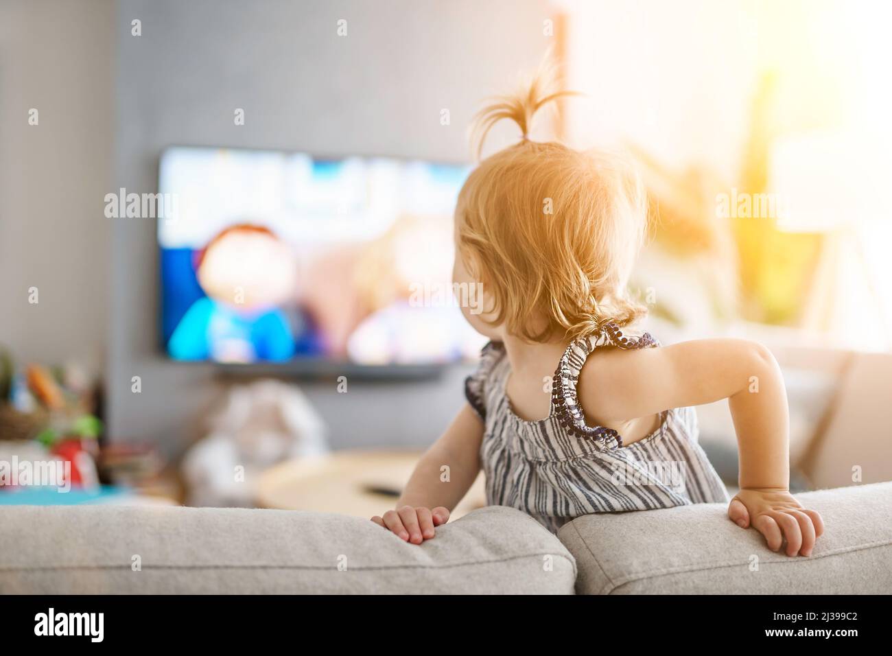 petite fille mignonne de regarder la télévision à la maison Banque D'Images