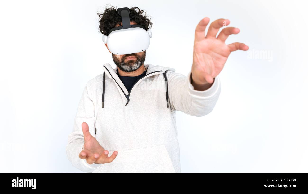 Homme barbu regardant un film avec un casque à lunettes VR sur fond blanc. Jouer au simulateur de jeu vidéo Profitez de la réalité virtuelle futuriste immersive 3D Banque D'Images