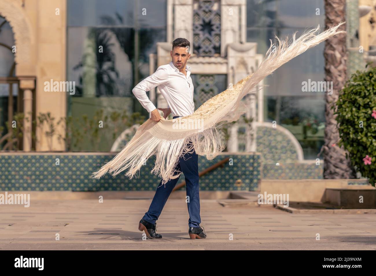 danseur espagnol de flamenco habillé en bleu et blanc déplaçant un manton autour de son corps Banque D'Images
