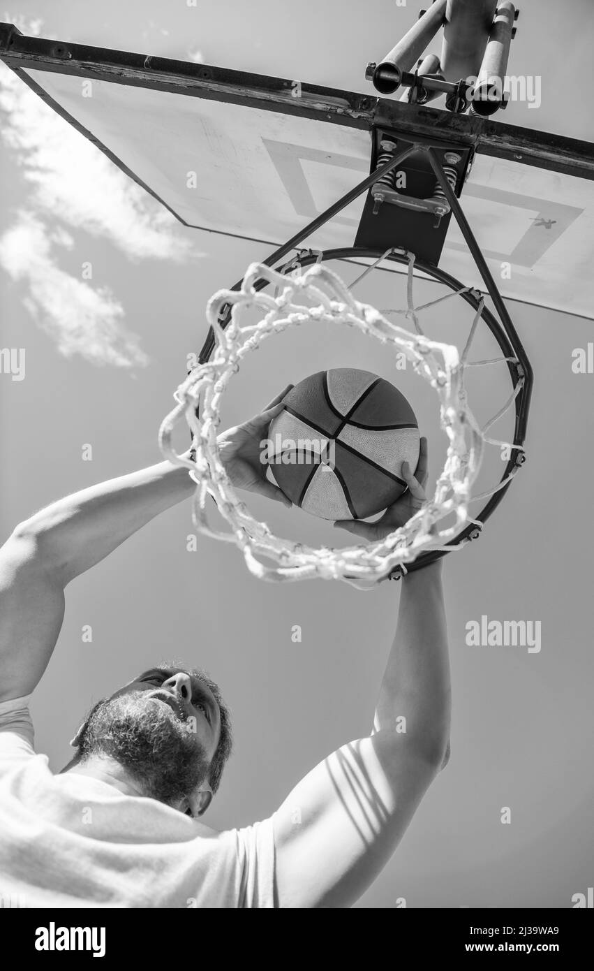 dunk dans le panier. slam dunk en mouvement. activité estivale. homme énergique avec ballon de basket-ball Banque D'Images