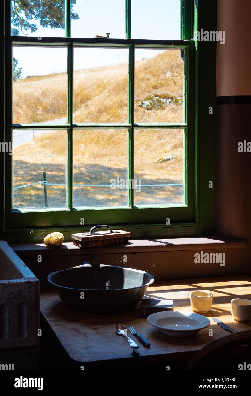 Ancienne maison de ferme intérieur d'une ancienne cuisine de maison de campagne. Cuisine maison rurale avec table en bois usée et bol à mélanger, cuillère, assiette. Mise au point sélective Banque D'Images