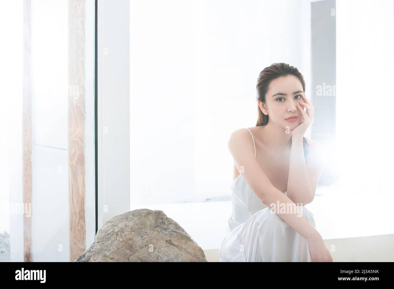 Belle jeune femme qui fait le soin de la peau dans un cadre moderne d'ameublement - photo de stock Banque D'Images