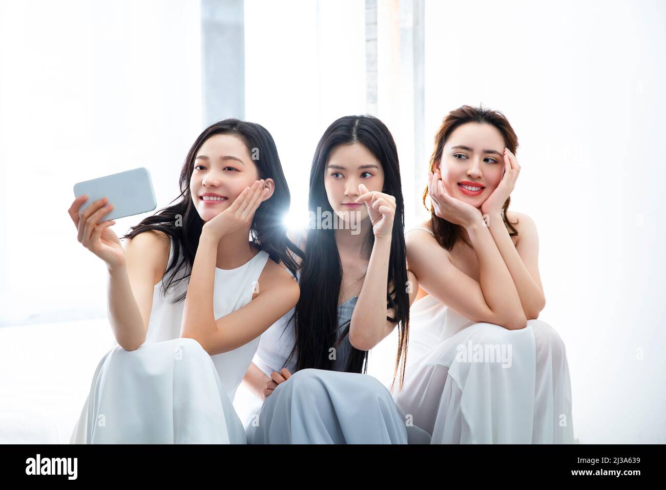 Jeunes femmes habillées de façon tendance prenant des selfies avec un smartphone - photo de stock Banque D'Images