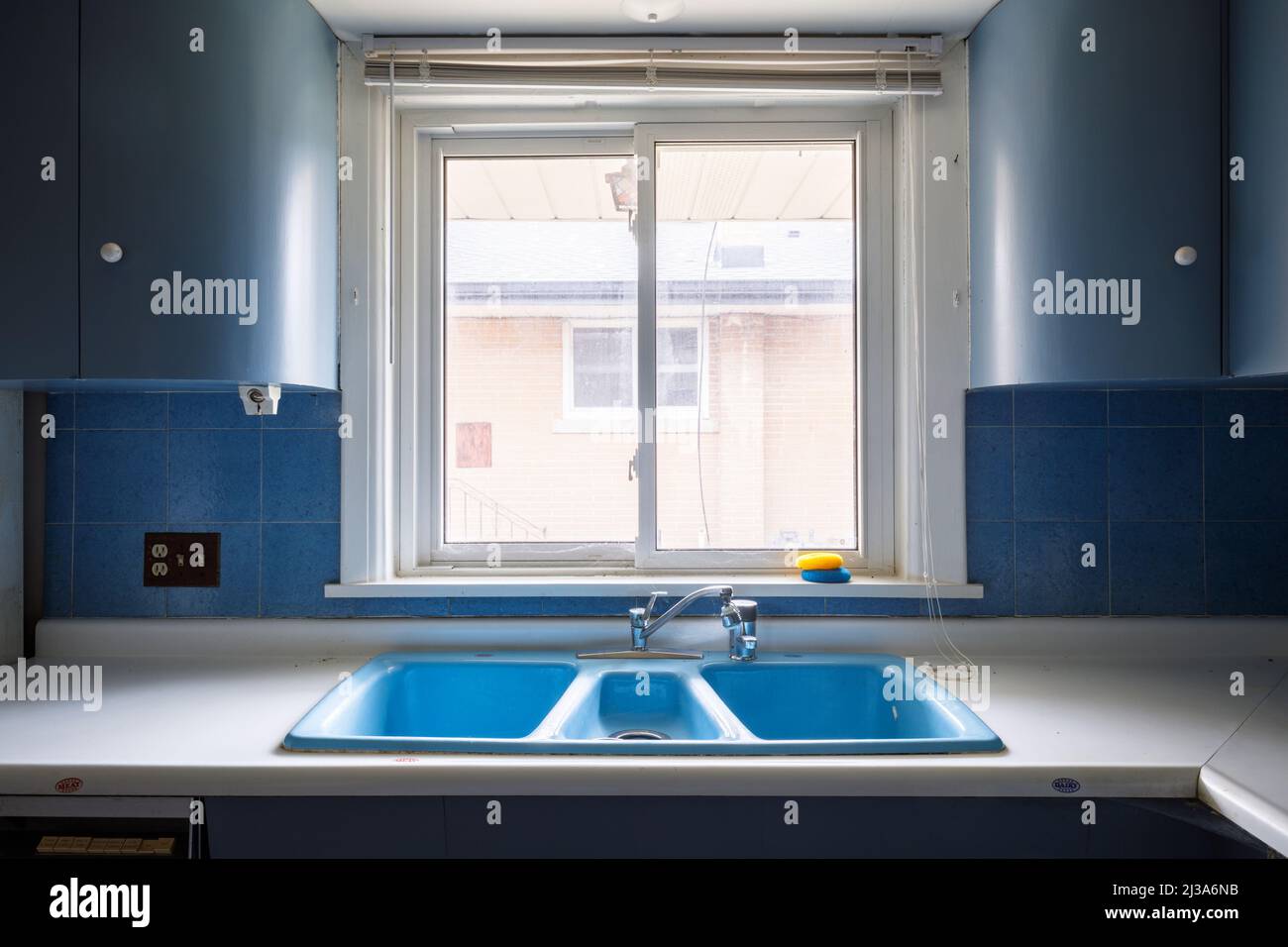 Un évier de cuisine bleu étrange et rétro. Cette maison a depuis été démolie. Banque D'Images