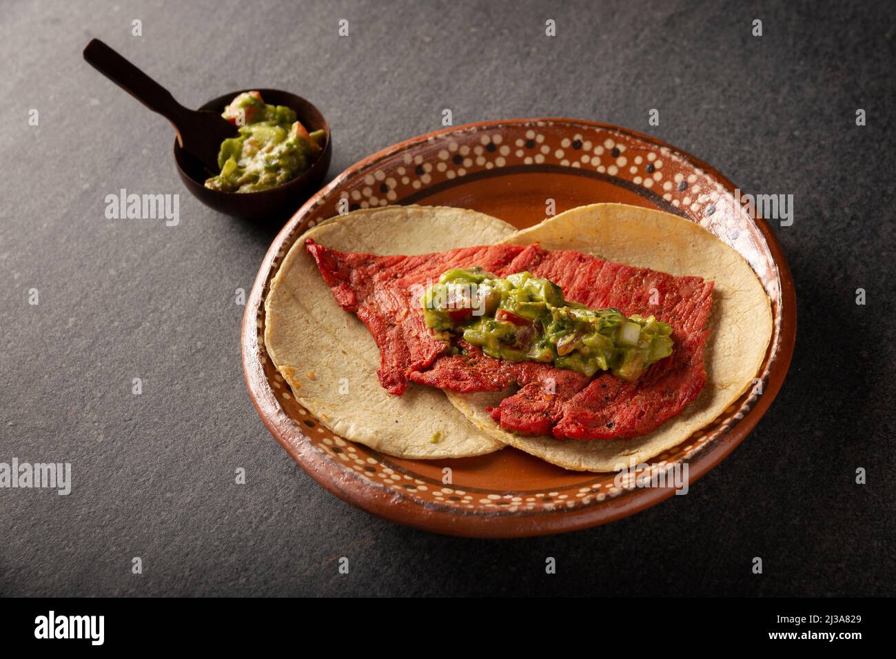 Tacos de Cecina enchilada con Guacamole. Viande de porc ou de bœuf salée et séchée au soleil, assaisonnée de diverses épices et de piments, généralement mangée dans des tacos Banque D'Images