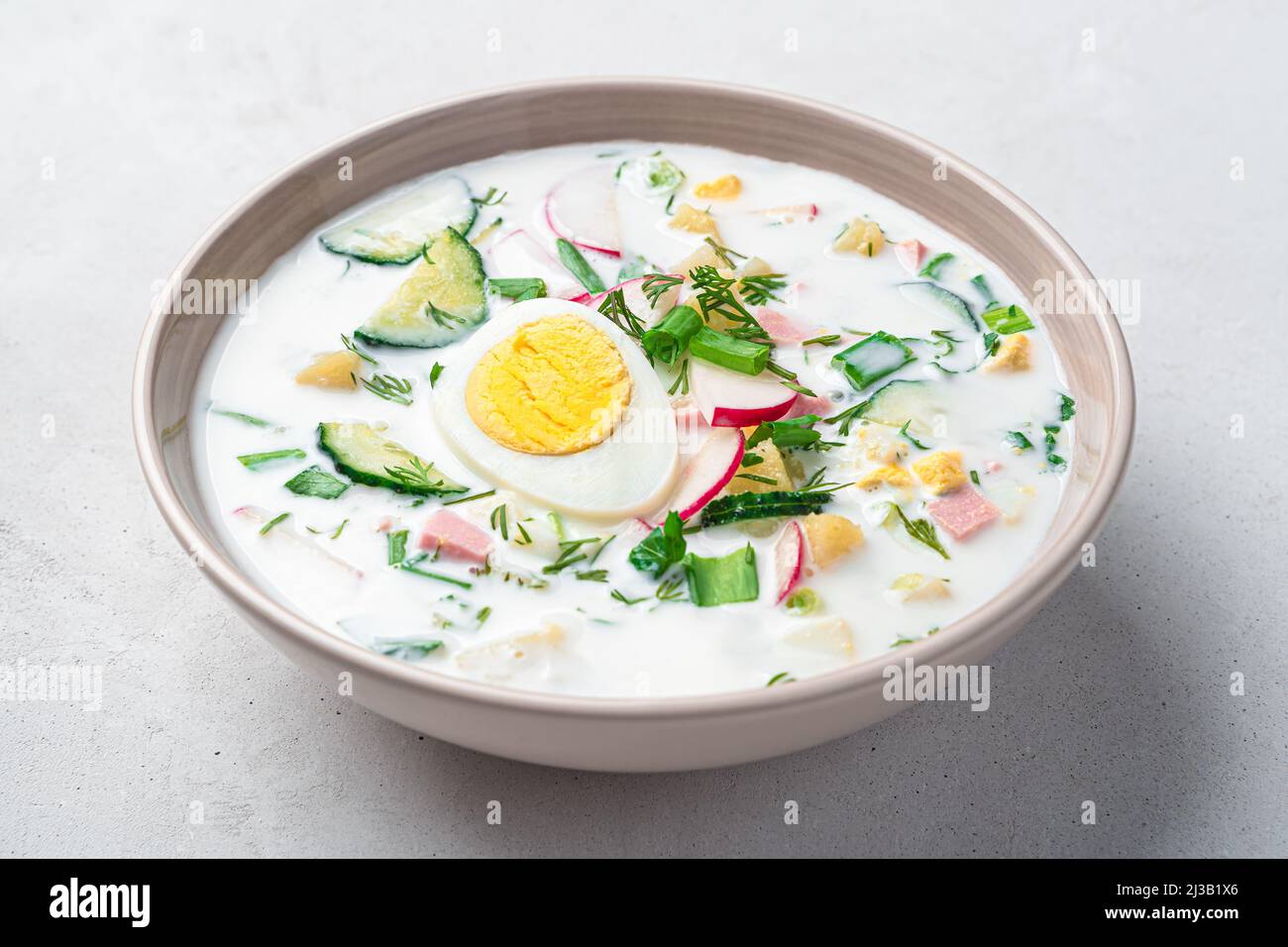 Soupe froide d'été à l'okroshka avec légumes, œufs, herbes fraîches et kéfir. Vue latérale, gros plan. Banque D'Images