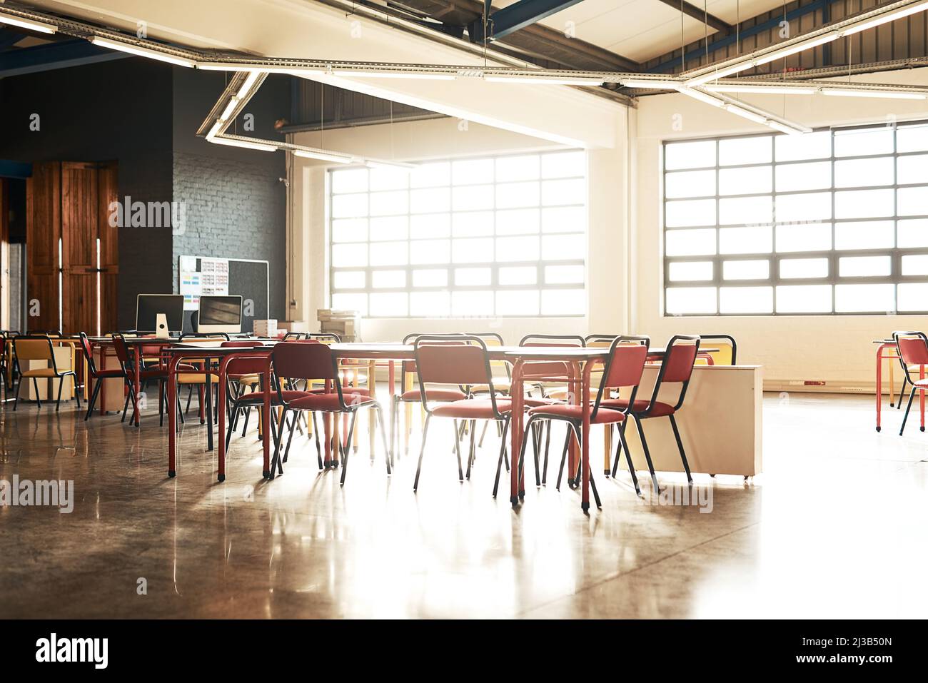 Le bureau ne fonctionnera pas à moins que nous ne le fassions. Photo d'une table et de chaises dans un bureau ouvert sans personne. Banque D'Images