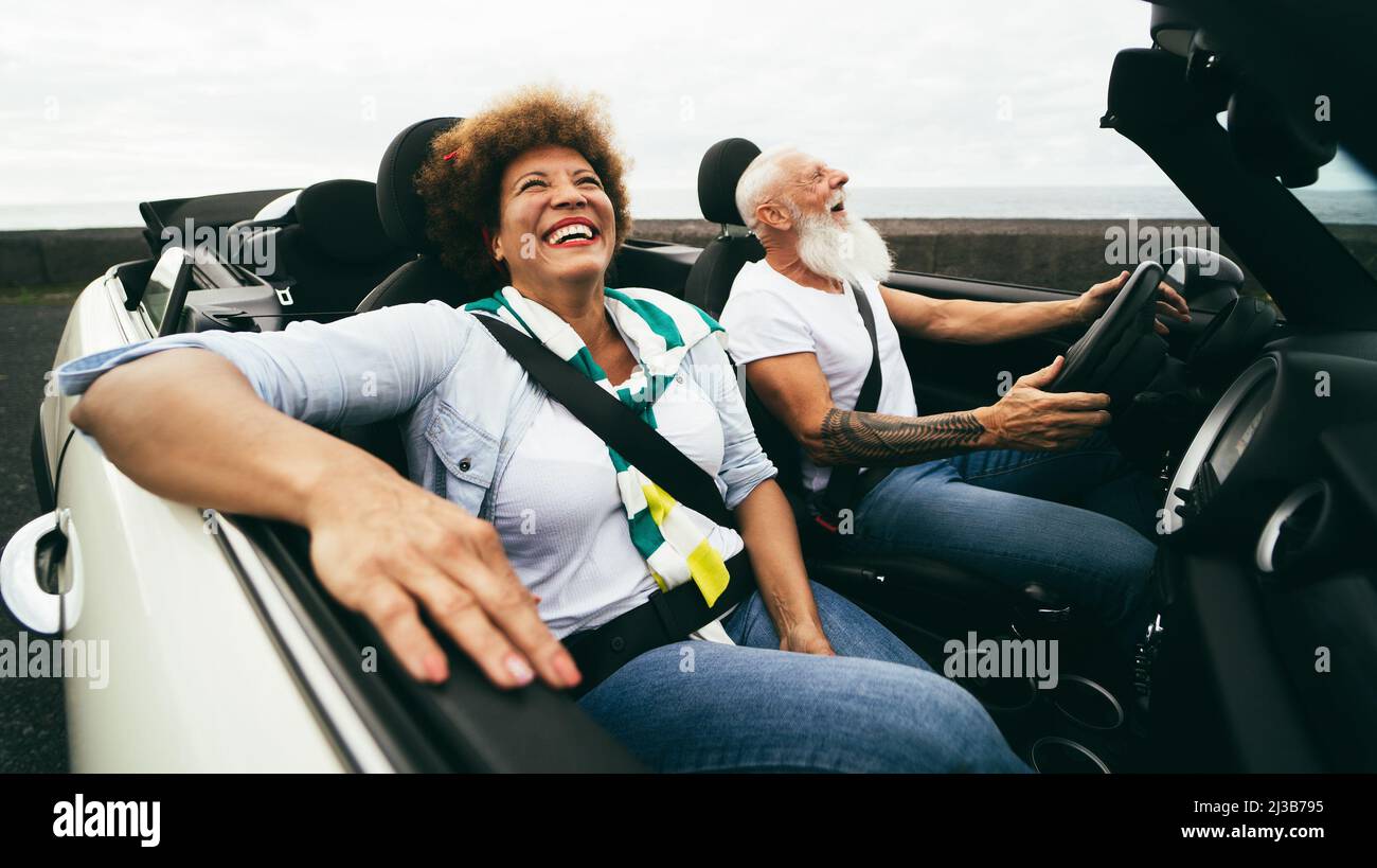 Joyeux couple senior qui s'amuse en voiture décapotable pendant l'été Vacances - accent sur le visage de femme Banque D'Images Joyeux couple senior qui s'amuse en voiture décapotable pendant l'été Vacances - accent sur le visage de femme Banque D'Images