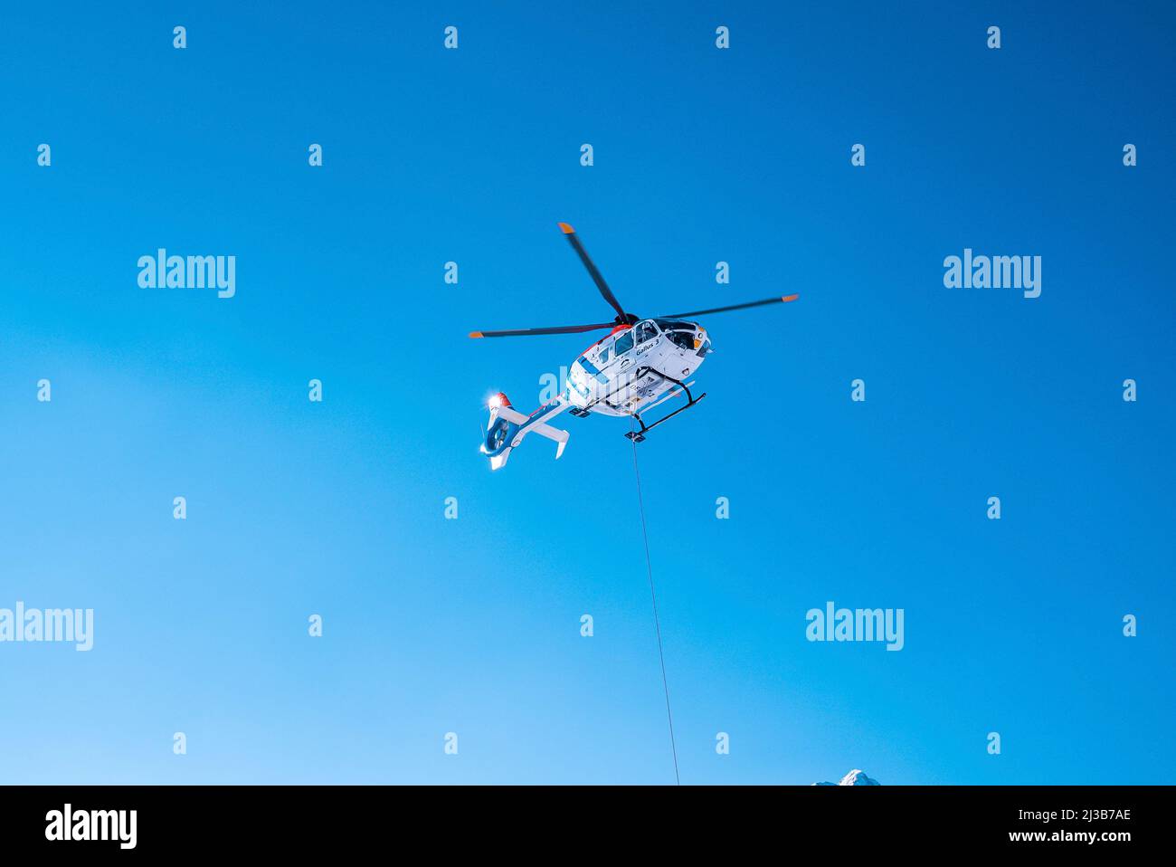 Hélicoptère de police survolant contre le ciel bleu par beau soleil Banque D'Images