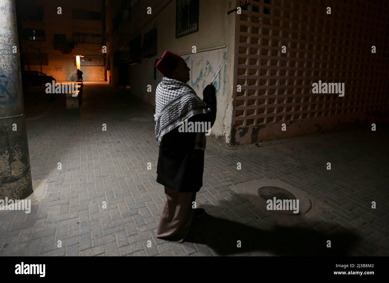 Khan Yunis, bande de Gaza, Palestine. 6th avril 2022. Khan Yunis, bande de Gaza, Palestine. 05 avril 2022. Le Nizar palestinien Al-Dabbas fait des torses dans les rues de Khan Younis qui battaient un tambour avant l'aube pendant le mois sacré musulman du Ramadan. La figure du batteur musulman ou 'Masaharati' fait partie d'une vieille tradition dans le but de réveiller les musulmans et de leur rappeler le repas suhoor précédant le jeûne (Credit image: © Yousef Mohammed/IMAGESLIVE via ZUMA Press Wire) Banque D'Images