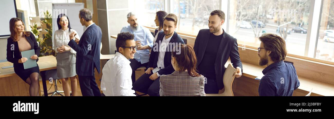 Divers groupes de personnes discutant de l'atelier de formation d'équipe auxquels ils viennent de participer Banque D'Images