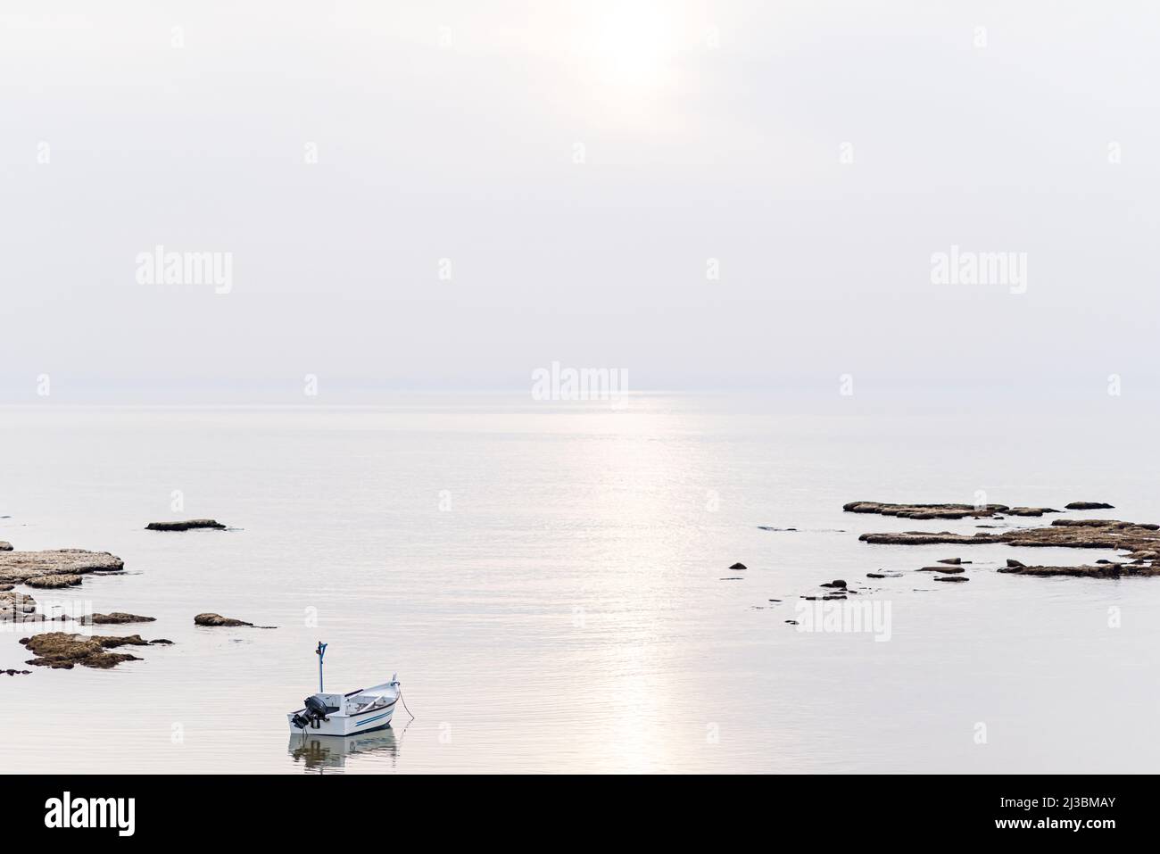Un petit bateau de pêche sur la plage de Jaffa, par une journée brumeuse. Concept de paix, de calme et de sérénité. Photographie de haute qualité. Photo de haute qualité Banque D'Images