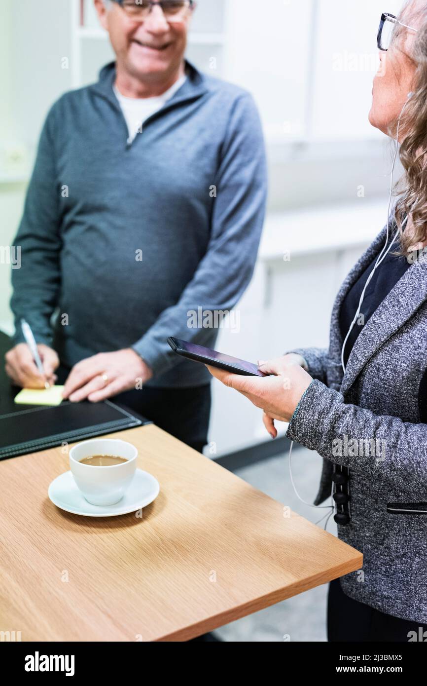 Collègues travaillant et buvant du café Banque D'Images