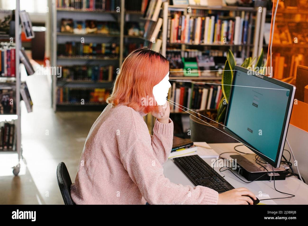 Une étudiante utilisant un ordinateur dans la bibliothèque Banque D'Images