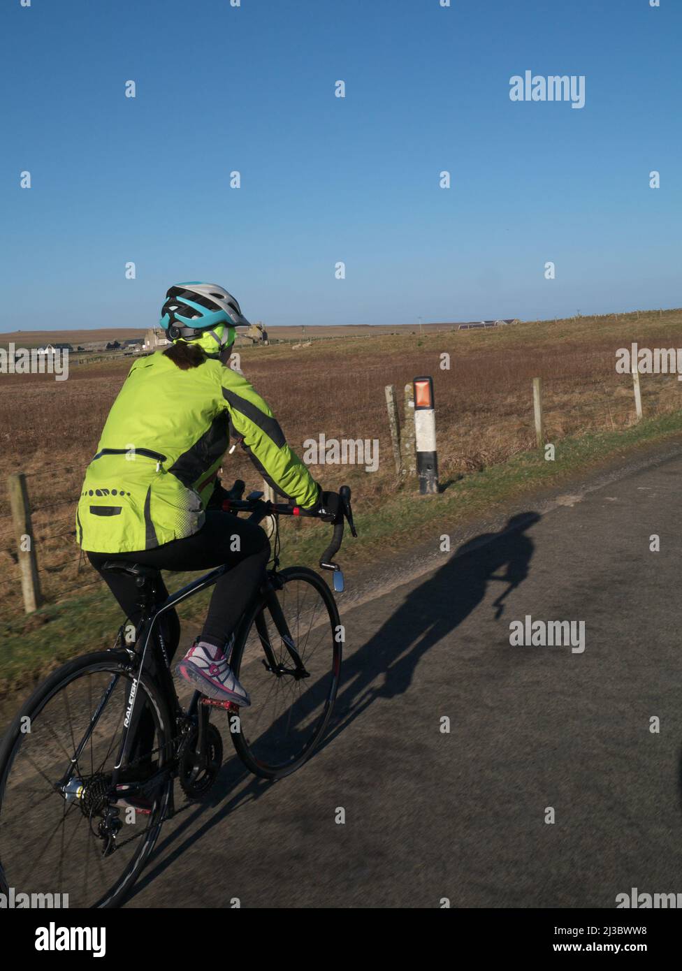 Femme vélo sur vélo de course à Orkney, Écosse Banque D'Images