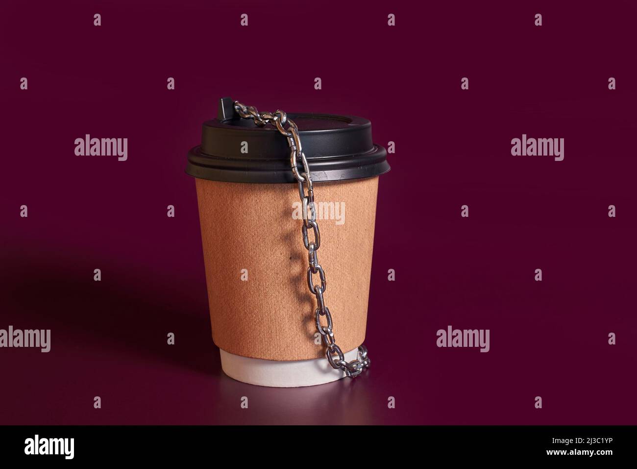 Dépendance à la caféine. Tasse en papier de café enveloppée d'une chaîne Banque D'Images